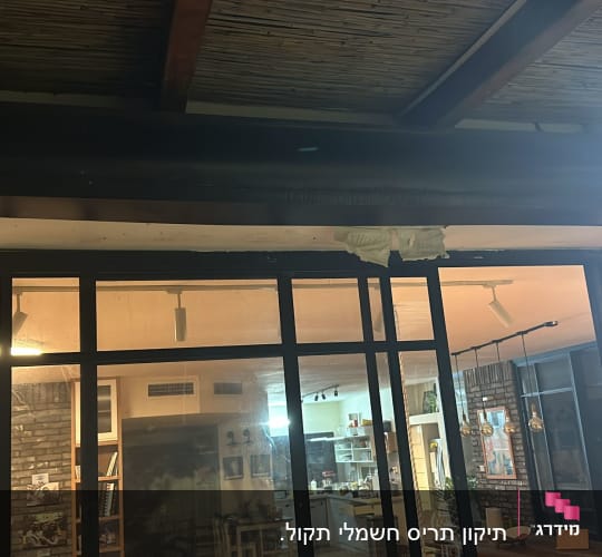 תריסים סגורים מעל חלון זכוכית גדול